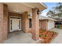 Inviting front porch of a brick home with manicured landscaping and outdoor lighting at 1600 Amboy Dr, Deltona, FL 32738