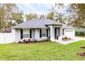 Inviting single-story home featuring lush landscaping, dark shutters, and a two-car garage at 1621 Crescent Rd, Longwood, FL 32750
