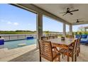 Covered patio with outdoor dining area overlooking pool and scenic lake view at 16828 Sanctuary Dr, Winter Garden, FL 34787