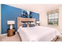 Stylish bedroom with a luxurious upholstered headboard and a serene blue accent wall at 2486 Dubai St, Kissimmee, FL 34747