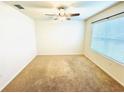 A simple bedroom with carpeted floors, a large window, and bright natural light at 2837 Palatino Lane, Tavares, FL 32778