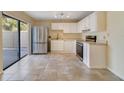 Bright kitchen features tile floors, stainless steel refrigerator, and white cabinets at 4036 Shannon Brown Dr, Orlando, FL 32808