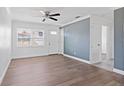 Bright living room featuring wood-look flooring, ceiling fan, and fresh paint at 4536 San Sebastian Cir, Orlando, FL 32808