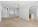 Open-concept living room boasting neutral carpeting, an arched entryway, and plenty of natural light at 536 Kilimanjaro Dr, Kissimmee, FL 34758