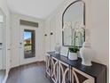 Inviting entryway features a decorative console table with an arched mirror and views of the front yard at 5852 Galloping Dr, Apopka, FL 32712