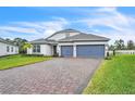 Charming two-story home with a brick driveway, manicured lawn, and gray paint at 6105 Citrus Grove Ct, St Cloud, FL 34771
