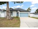 Charming home with a well-manicured lawn, blue garage door, and ample driveway space at 7633 Marietta St, Orlando, FL 32807