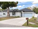 Charming home with a well-manicured lawn, blue garage door, and ample driveway space at 7633 Marietta St, Orlando, FL 32807