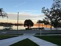 Scenic view of a serene lake at sunset, framed by lush trees and a charming dock at 806 Edgewater Dr, Orlando, FL 32804