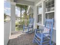 Cozy front porch featuring blue rocking chairs, a small side table, and decorative cushions at 10012 Lovegrass Ln, Orlando, FL 32832