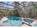 Sparkling screened-in pool and spa surrounded by lush landscaping for ultimate relaxation at 1025 Sandy Ridge Dr, Davenport, FL 33896