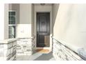 Elegant front door with stone trim and sidelight, creating a grand entrance to the home at 1038 Dennis Ave, Orlando, FL 32807