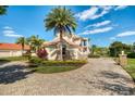 Side view of a lovely two-story home featuring a circular driveway, stone accents, and mature landscaping at 11234 Willow Gardens Dr, Windermere, FL 34786