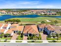 Beautiful aerial view of the property with a red tile roof and a great lake and golf view at 13319 Alderley Dr, Orlando, FL 32832