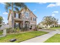 Two-story home showcasing a blend of stone and stucco, complemented by a brick driveway and manicured lawn at 1700 Leatherback Ln, St Cloud, FL 34771