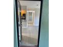 A view from the front door showcasing the hallway with a view into the kitchen and light wood floors at 2025 Dixie Belle Dr # 2025 B, Orlando, FL 32812