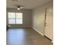 A well-lit room with light floors and walls and a fan, showing views of the windows and entryway at 2025 Dixie Belle Dr # 2025 B, Orlando, FL 32812