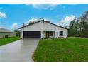 Attractive single-story home featuring a dark garage door and well-maintained landscaping at 2246 Sw 167Th Pl, Ocala, FL 34475