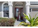 Elegant front entrance with double doors, decorative glass, and lush landscaping at 2732 Aloma Oaks Dr, Oviedo, FL 32765