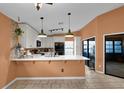 Well-lit kitchen featuring white cabinetry, breakfast bar, and sliding glass doors at 3038 Woolridge Dr, Orlando, FL 32837