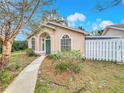 Inviting home with manicured lawn, featuring arched windows, green door, and a quaint walkway at 310 Sunvista Ct, Sanford, FL 32773