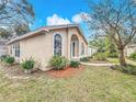 Charming exterior with arched windows, green door, and a well-maintained lawn with manicured landscaping at 310 Sunvista Ct, Sanford, FL 32773