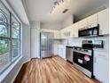 Well-lit kitchen with stainless steel appliances, wooden floors and neutral cabinets at 310 Sunvista Ct, Sanford, FL 32773