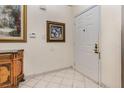 Clean foyer showcasing a tiled floor, white walls, a white door, and an accent cabinet at 314 Silk Oak Dr, Kissimmee, FL 34743