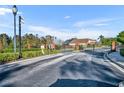 Gated community entrance with brick columns, black wrought iron gates, and mature landscaping at 3664 Sickle St, Orlando, FL 32812