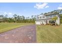 Expansive property showcasing the house's brick driveway, sizable lawn and wooded backdrop, promoting a serene setting at 3916 Clipstone Pl, Sanford, FL 32773