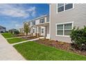 A row of townhomes with beautiful lawns and landscaping on a sunny day at 6068 Peaceful Pkwy, Clermont, FL 34714