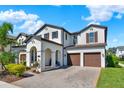 Lovely two-story home boasts a brick driveway, manicured lawn, attached two-car garage, and covered front porch at 8330 Vivaro Isle Way, Windermere, FL 34786