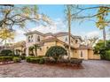 Elegant two-story home with tile roof, manicured landscaping, and brick paver driveway at 8814 Southern Breeze Dr, Orlando, FL 32836