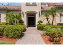 Inviting front entrance with a brick pathway leading to a striking double door and lush landscaping at 8814 Southern Breeze Dr, Orlando, FL 32836