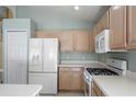 Well-equipped kitchen with white appliances, light wood cabinets and gas range at 112 Tate Ct, Orlando, FL 32828