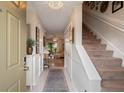 Bright foyer featuring an elegant light fixture, beautiful flooring, and staircase at 11735 Whitewing Ct # 11735, Orlando, FL 32837