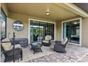 Relaxing covered patio area with comfortable wicker furniture and decorative outdoor accents at 1304 Sea Pines Way, Davenport, FL 33896