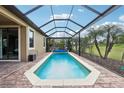 Enclosed pool with clear blue water, surrounded by a brick patio and a screened enclosure at 1304 Sea Pines Way, Davenport, FL 33896