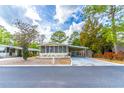 Cozy single-story home with a screened-in porch and covered parking, set against a backdrop of mature trees at 134 E Plantation Blvd, Lake Mary, FL 32746