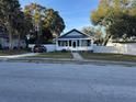 Charming bungalow with inviting front porch, fenced yard, and mature landscaping at 1404 High St, Leesburg, FL 34748