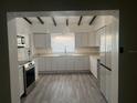 Bright kitchen featuring white cabinets, stainless steel appliances, light countertops, and wood-look flooring at 1907 Rockwell Rd, Orlando, FL 32808