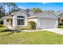 Inviting single-Gathering home with a well-manicured lawn, featuring a two-car garage at 2978 Stillwater Dr, Kissimmee, FL 34743