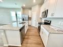 Modern kitchen featuring an island with white cabinets, granite countertops, and stainless-steel appliances at 316 South Zuni Rd, St Cloud, FL 34771