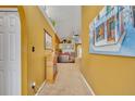 Interior hallway featuring neutral carpeting and decorative wall art leading to the living room at 3455 Bellingham Dr, Orlando, FL 32825