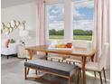 Bright dining room with wood table, seating for six, and large windows overlooking the backyard at 3665 Portsmouth Ln, Haines City, FL 33844