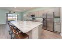 Bright kitchen with stainless steel appliances, spacious island with seating, and modern gray cabinets at 4115 Ruby Run, Haines City, FL 33844