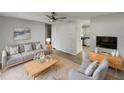 Comfortable living room featuring a stylish sofa, a ceiling fan, a modern TV, and neutral-toned decor at 437 Georgia Ave, St Cloud, FL 34769