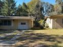 A single car garage adjacent to a single-story home showing the driveway and adjacent yard at 506 N Rio Grande Ave, Orlando, FL 32805