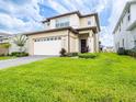 Two-story house with well-manicured green lawn, clean stucco, and two car garage at 5266 Buttonsage Dr, St Cloud, FL 34772