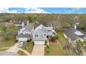 An aerial shot showcases this charming home nestled in a serene neighborhood with mature trees and manicured lawns at 5276 Rocking Horse Pl, Oviedo, FL 32765